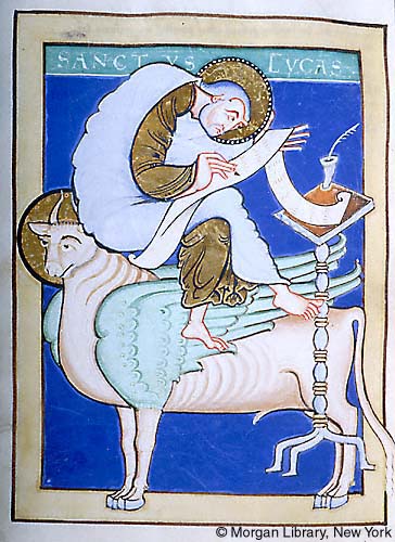 A manuscript illumination depicting a bearded man, wearing a gold halo, writing on a scroll and seated with crossed legs on the head and back of a winged ox, also wearing a halo. A tall lectern holding an inkhorn beside them. Blue background and Latin name inscription at top "Sanctus Lucas."