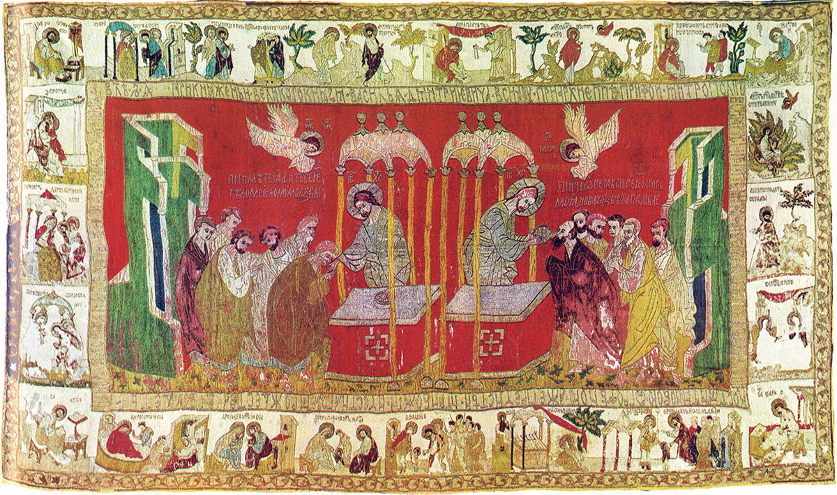 A veil embroidered with a a large center panel with a man standing at an altar and offering bread and wine to groups of other men. A border of smaller scenes surrounds the large center panel.