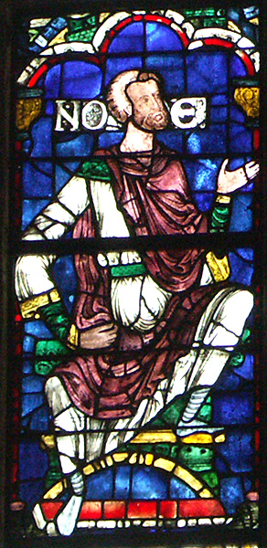 Stained glass panel containing a seated, bearded man placing his right arm on his waist and raising up his left hand; beside his head are the letters, N, O, and E.