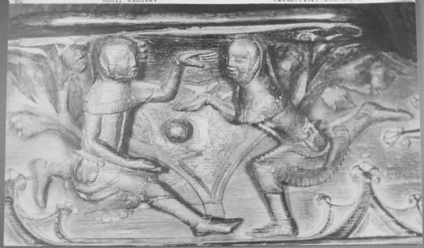 A wooden relief depicting two young men playing with a ball.