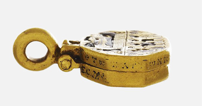 A side view of a gold reliquary pendant.