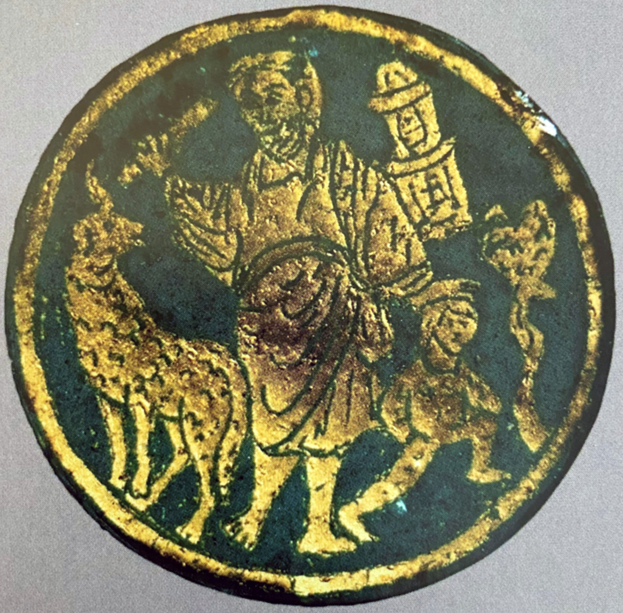 On a piece of gold glass, a figure wearing a tunic standing between a ram and a small, nude figure.