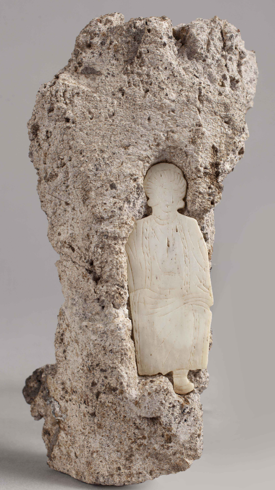 Bone plaque representing female figure set in mortar.