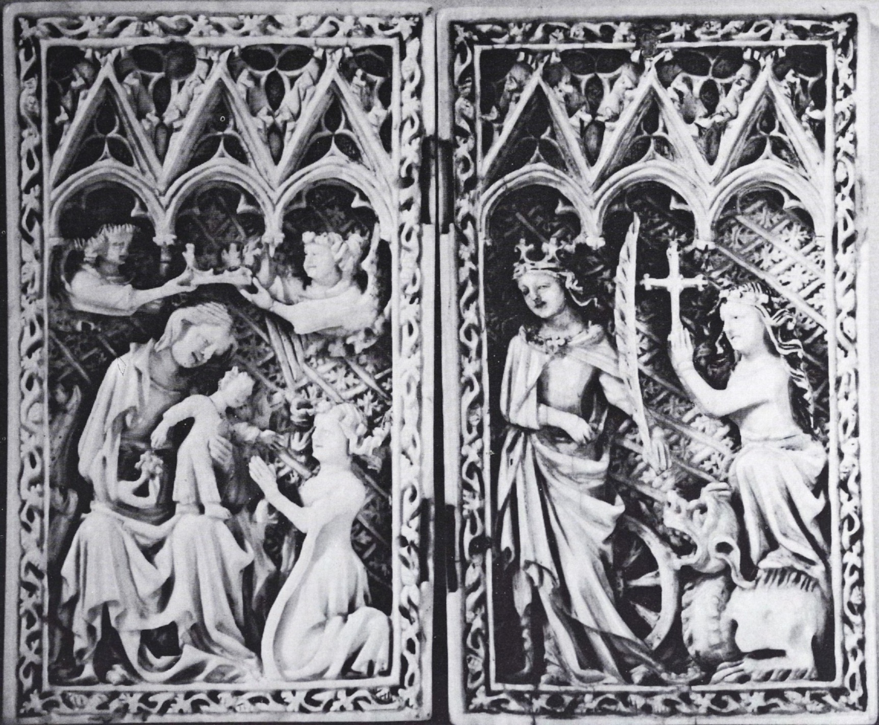 On a carved ivory diptych, a figure kneeling before a child on a woman’s lap, a woman standing next to a wheel and holding a palm branch, and a woman standing with one foot on a dragon and holding a cross.