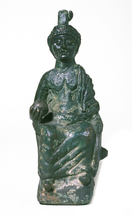 Frontal view of a bronze statuette of a crowned male figure seated on a bench. He is holding a globe in his right hand and a shield in his left.