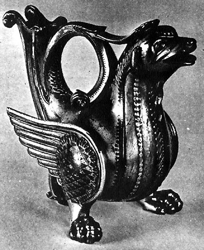 A golden metal vessel in the shape of a dragon with a raised tail and open mouth, facing right.