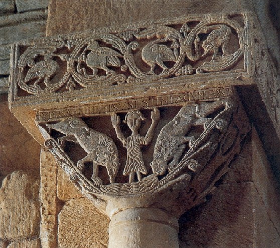 A stone block that contains a carving of a man flanked by two lions.