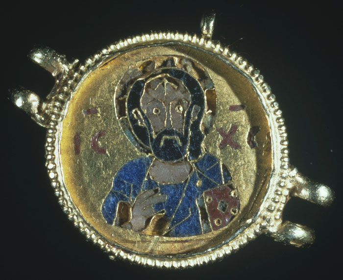 On a gold and enamel medallion, the bust of a man holding a book.