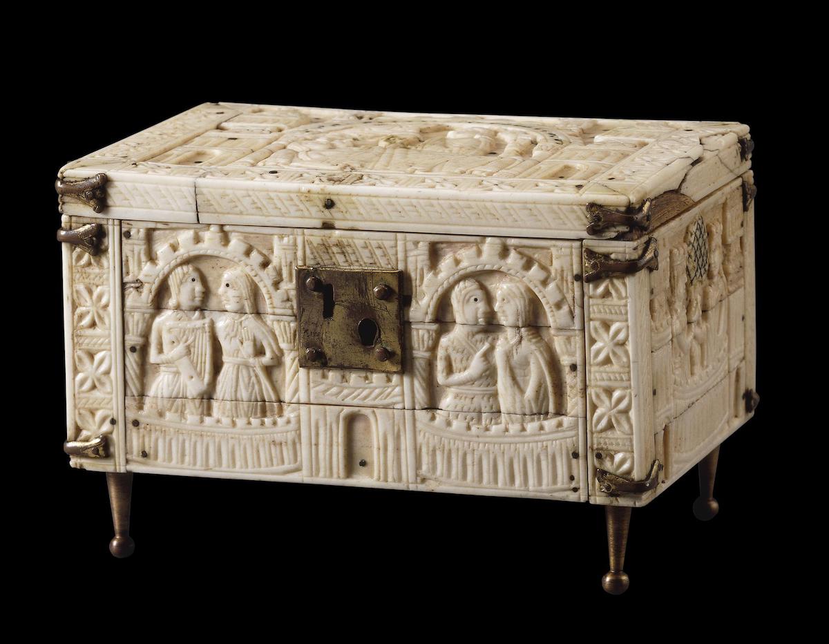 Carved ivory casket with scenes of courting couples in architectural niches and with rose decoration; copper-gilt lock, braces and feet.