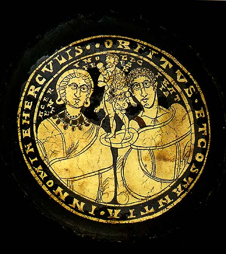 Medallion with textual frame, enclosing small, bearded figure of man wearing a lion’s skin, flanked by female and male figure, each depicted from the waist up;  all below inscription. 