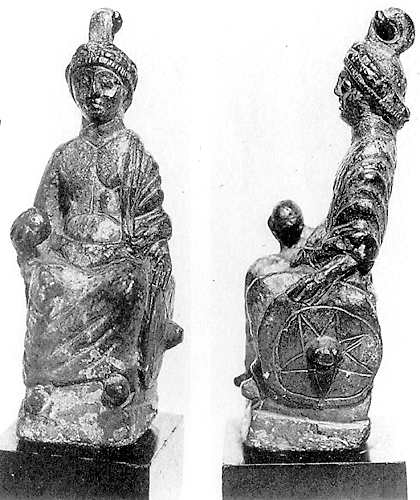 Frontal view and left profile of a bronze statuette of a crowned male figure seated on a bench. He is holding a globe in his right hand and a shield in his left.