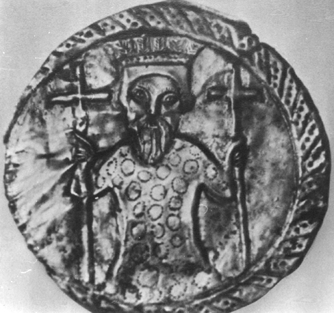 Metal plaque containing medallion with king wearing crown and holding a cross in each hand.