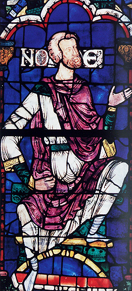 Stained glass panel containing a seated, bearded man placing his right arm on his waist and raising up his left hand; beside his head are the letters, N, O, and E.
