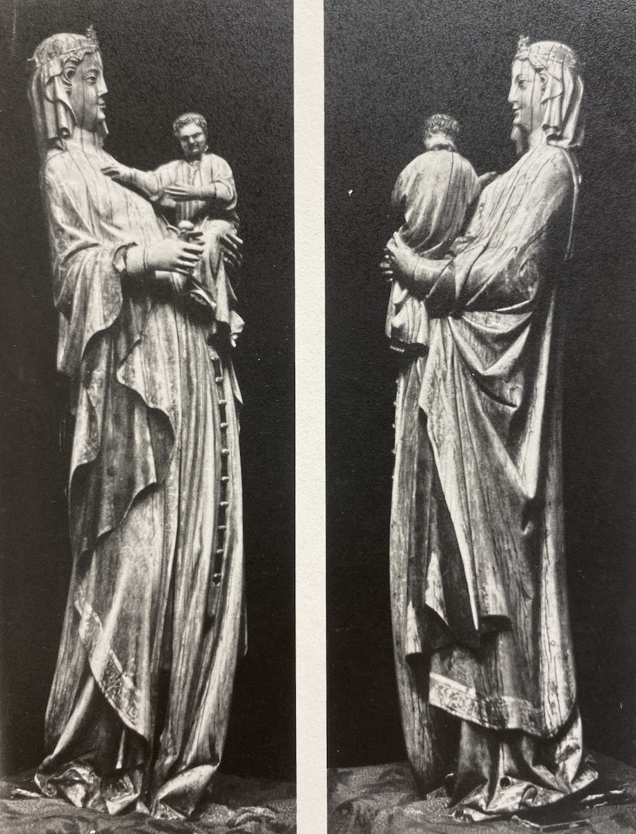 Two views of a carved ivory statuette of a veiled woman, wearing long belted garment, holding a male child in her left arm and a bud of a flower in her other hand.