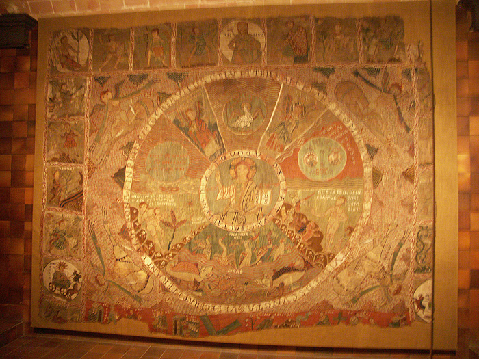An embroidered tapestry depicting God surrounded by biblical scenes, personifications of the months, and other figures.