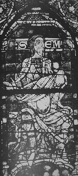 Black and white photo of a stained glass panel containing a seated, bearded man raising his right hand; beside his head are the letters, S, E, and M.