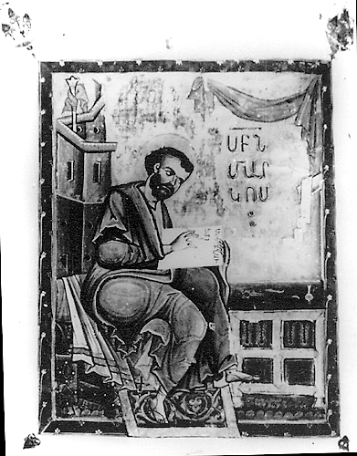 A black and white photograph of a full-page illuminated page that depicts a bearded man seated on a bench and writing text in an open book next to a desk. There is Armenian text on the right side of the illumination.